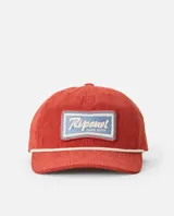 Gorro tipo gorra de pana color rojo ladrillo, con visera curva, cordón decorativo blanco en la base de la corona y parche bordado rectangular con diseño surf shop en tonos celestes y blancos.