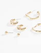 Set de tres pares de aros dorados: un par de aros tipo botón, un par de aros argolla con incrustaciones de perlas y strass, y un par de aros argolla irregulares con una perla en el extremo.