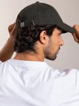Gorro con visera color verde oscuro, de lana y poliéster, con logo de pájaro bordado en plateado en el frente.