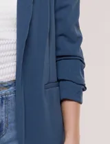 Blazer de crep color bordó de la marca BBJ, con cuello solapa, bolsillos delanteros y mangas tres cuartos con frunce.