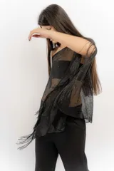 Poncho de tejido calado negro con apliques de piedras y flecos.