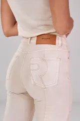 Jeans de denim color beige, de tiro alto y corte recto, con costuras verticales decorativas en el frente.