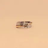 Anillo de diseño apilable compuesto por dos piezas: una banda superior con textura estriada y detalle central en oro, y una banda inferior de diseño liso y minimalista en plata.