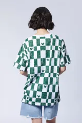 Remera de manga corta con estampado de cuadros verdes y blancos, con pequeños motivos de la silueta de Mickey Mouse dispersos por el diseño.