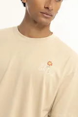 Remera verde con estampado pequeño en el pecho que dice "We all grow".