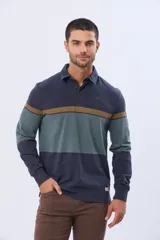 Remera polo de manga larga con diseño de bloques de color horizontales en tonos azul, verde y marrón. Presenta cuello clásico, cierre frontal con botones y bordado en el pecho. Cuenta con puños elásticos acanalados.