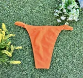 Conjunto de bikini naranja, con corpiño triangular fijo y bombacha vedetina regulable.