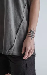 Sudadera sin mangas (tipo musculosa) color gris oscuro con efecto gastado, confeccionada en algodón premium. Presenta recortes diagonales en el delantero y hombros, y un calce oversize.