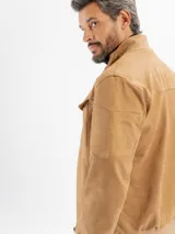 Campera de estilo casual confeccionada en tejido suave con textura tipo gamuza. Presenta cuello alto, cierre frontal, bolsillos laterales y bolsillos frontales con solapa. Incluye detalles de costuras en las mangas y terminaciones elastizadas en puños y cintura.