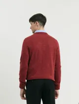 Sweater de tejido de punto con escote redondo y manga larga, con detalles de costuras en sisas y cuello. Presenta un diseño clásico y versátil.