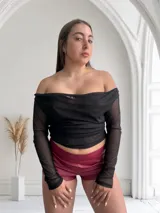 Top negro de tul con escote bardot y mangas largas.