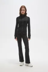 Campera deportiva negra de ajuste al cuerpo, con cierre frontal completo, cuello alto y mangas largas con orificio para el pulgar.