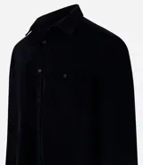 Camisa de hombre color verde oscuro, confeccionada en terciopelo, con cuello clásico, manga larga y dos bolsillos frontales con solapa y botón. Cierre frontal con botones.