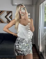 Musculosa lencera blanca con encaje, escote pico y tirantes finos. Bajo asimétrico.