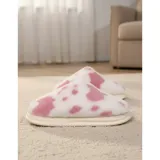 Pantuflas sin talón confeccionadas en algodón afelpado y piel sintética, con divertido estampado de manchas de vaca en tonos blanco y marrón, y suela de PVC.
