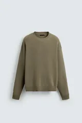 Jersey de corte relajado confeccionado en tejido de algodón. Presenta cuello redondo, manga larga y acabados en rib en puños, cuello y bajo.