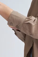 Camisa oversize color visón, de manga larga y corte holgado.