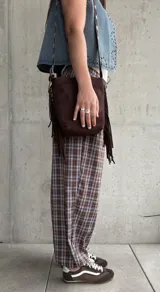 Pantalón babucha de corte holgado, con estampa de cuadros en tonos marrón y celeste, cintura elástica con cordón ajustable y puños fruncidos en los tobillos.