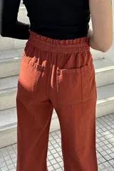 Pantalón de jean color beige, de corte ancho, recto y de tiro alto. Tiene elástico y pinzas en la pretina.
