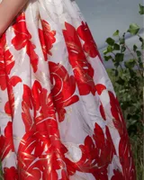 Falda midi de seda natural color crema con estampado floral en tonos rojo y dorado.