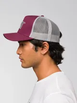 Gorro trucker Caterpillar color bordó con parte trasera de red gris, visera curvada y logo bordado en relieve en el frente.