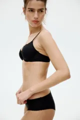 Pack de tres bombachas negras de microfibra con ribetes de encaje y moño decorativo.