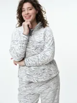 Buzo de dormir de tela fleece con estampado animal print en tonos grises y blancos. Presenta cuello alto con cierre de botones a presión y mangas largas.