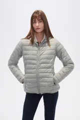 Campera acolchada tipo puffer, color beige claro, con capucha y cierre frontal. Presenta costuras horizontales y un calce entallado.