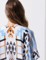 Kimono tejido con estampado de rayas azules y blancas, mangas amplias estilo japonés y terminación de ruedo con borlas azules.