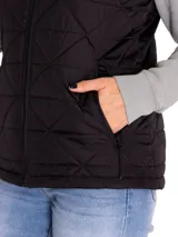 Chaleco acolchado de color negro con diseño de rombos, cierre frontal completo y bolsillos laterales con cierre. Presenta cuello alto y es resistente al agua y al viento.