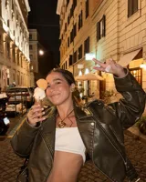 Collar con dije de forma irregular en tonos dorados y plateados, suspendido de un cordón doble de algodón negro.