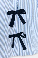 Blusa de cuello redondo y escote pico con manga corta abullonada acabada en elástico. Detalle de lazos a contraste en delantero. Bajo recto.