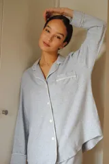 Conjunto de pijama de algodón gris con estampado geométrico blanco, compuesto por una camisa de manga larga con botones y un pantalón largo con elástico en la cintura.