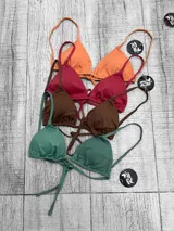 Corpiño de bikini tipo triángulo con copas removibles. Se ata en la espalda y tiene tiras ajustables que también permiten atarlo al cuello.