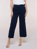 Pantalón crop blanco de corte recto con cintura ancha y botones decorativos laterales. Cuenta con bolsillos y pinzas frontales.