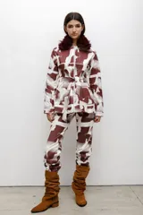 Parka con estampado abstracto en tonos bordó y blanco, cuello de piel sintética, cierre frontal y lazo ajustable en la cintura.