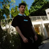 Remera con cuello tipo polo color marrón con cuello celeste, de tela de algodón grueso y estampado en serigrafía tipo puf tanto en pecho como en espalda.