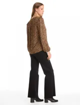 Blusa de gasa con estampado animal print, cuello a la base con escote en V y cierre frontal, manga larga con puños elastizados.