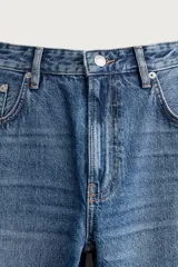 Jeans de corte slim cropped confeccionados en denim de algodón rígido con efecto lavado. Presentan tiro medio, cierre frontal con cremallera y botón, y diseño clásico de cinco bolsillos.