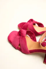 Sandalia de tacón cuadrado medio, confeccionada en terciopelo negro. Presenta un diseño de tiras cruzadas con nudo en la parte delantera y una tira ajustable con hebilla en el tobillo.