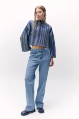 Sweater tejido de punto a rayas texturizado con lurex, color verde y azul. Cuenta con un calce oversize, mangas tres cuartos y cuello bote.