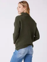 Buzo de tejido acanalado color blanco, con cuello alto y diseño de patrón en V en el frente. Presenta un corte holgado con mangas integradas sin costura de sisa.