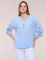 Blusa Erika de algodón con estampado de rayas en tonos azules, rosados y amarillos. Presenta cuello redondo con escote en V y botones frontales, mangas cortas decoradas con una fila de botones en los laterales y dobladillo asimétrico.
