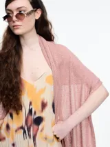 Chal tejido en hilado liviano color rosado con brillo sutil y pequeñas lentejuelas al tono. Diseño envolvente y fluido.