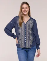Camisa azul marino de estilo boho, con cuello camisero, escote en V y cierre frontal con botones. Presenta una pechera con bordados geométricos y florales en tono crudo, y mangas largas abullonadas con puños abotonados.