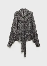Blusa de manga larga abullonada con estampado de leopardo en tonos grises y negros. Presenta cuello redondo con cierre de lazo.