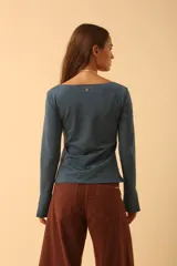 Remera de manga larga con cuello bote, confeccionada en tejido de algodón. Presenta un corte recto y aberturas laterales en los puños.