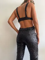 Top de bikini negro con lentejuelas, breteles anchos y espalda descubierta.