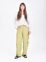 Pantalón cargo ancho de color verde oliva claro, con cintura elástica y bolsillos tipo parche a los lados de las piernas.
