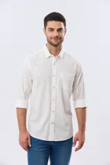 Camisa de lino lisa de manga larga en color blanco, con cuello camisero, cierre frontal con botones y un bolsillo aplicado en el pecho con detalle bordado.